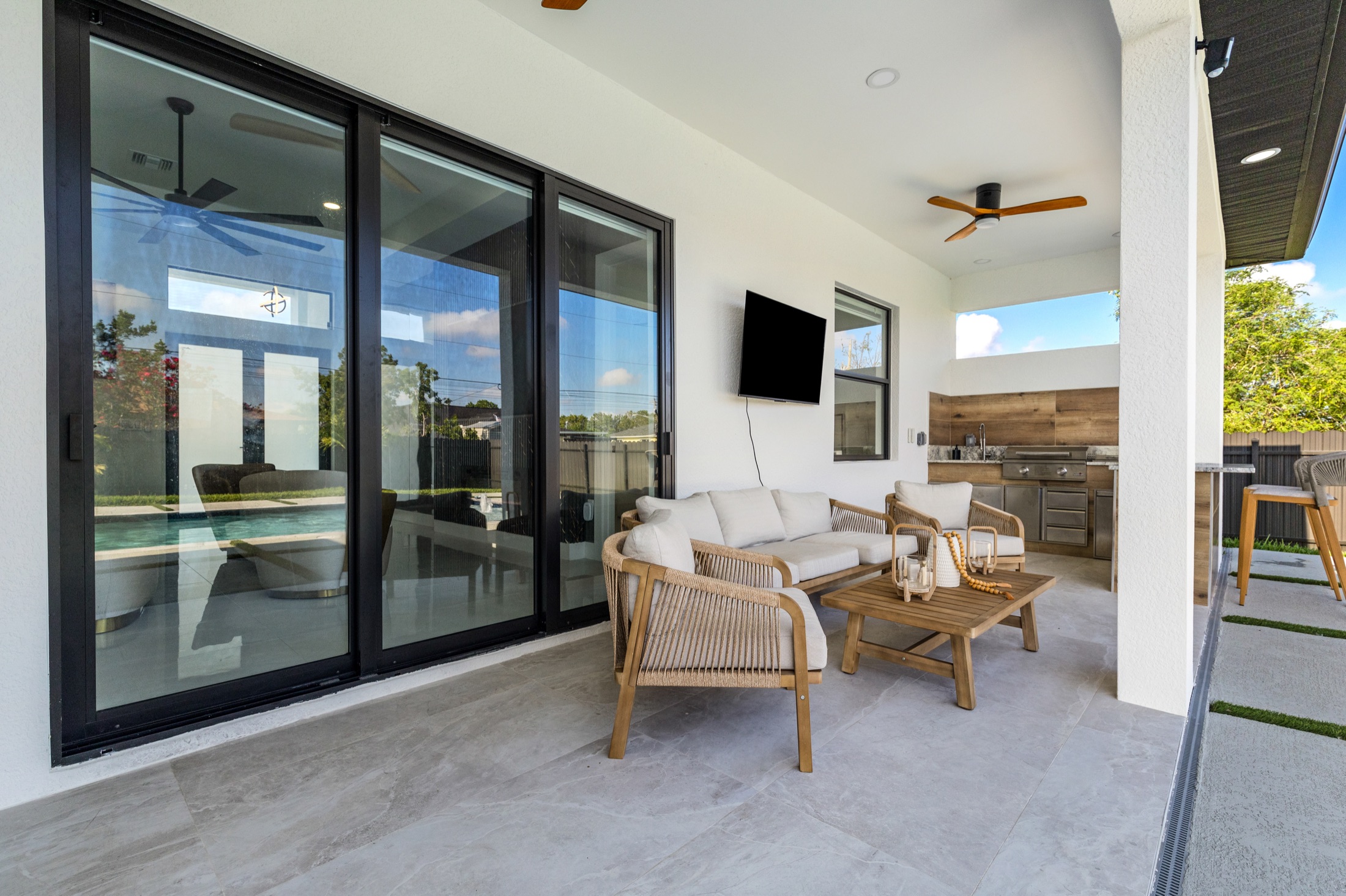 Covered outdoor living space beside a pool